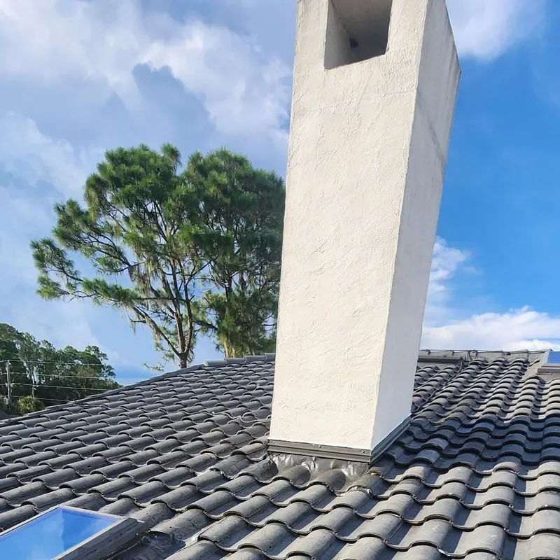 Finished tile roof around a stucco chimney after a Pro Specialty Services leak repair in Lake County, FL