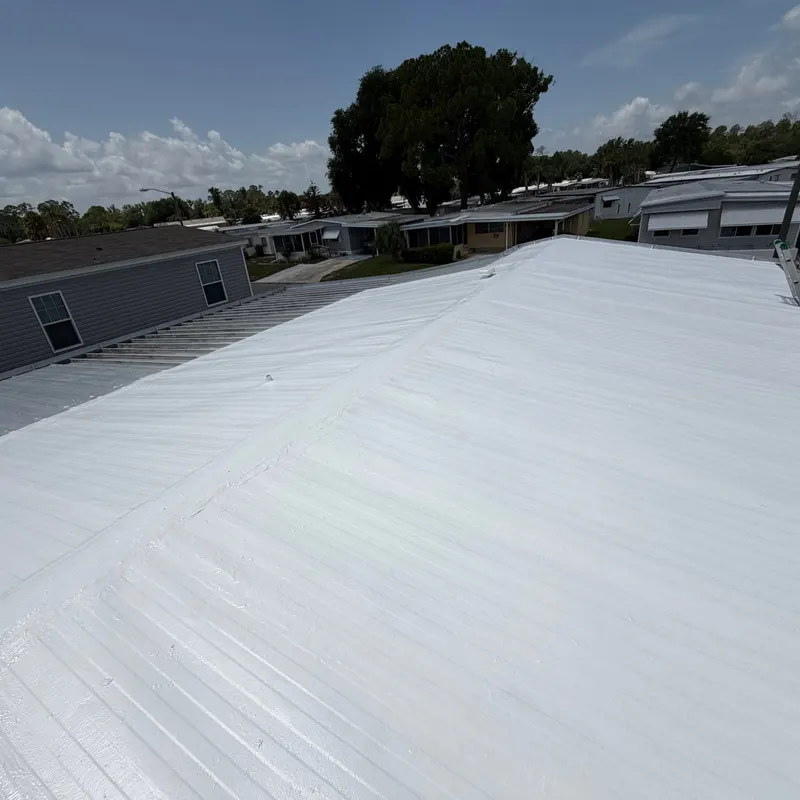 Mobile home metal roof in Leesburg, FL with a finished white silicone coating applied by Pro Specialty Services
